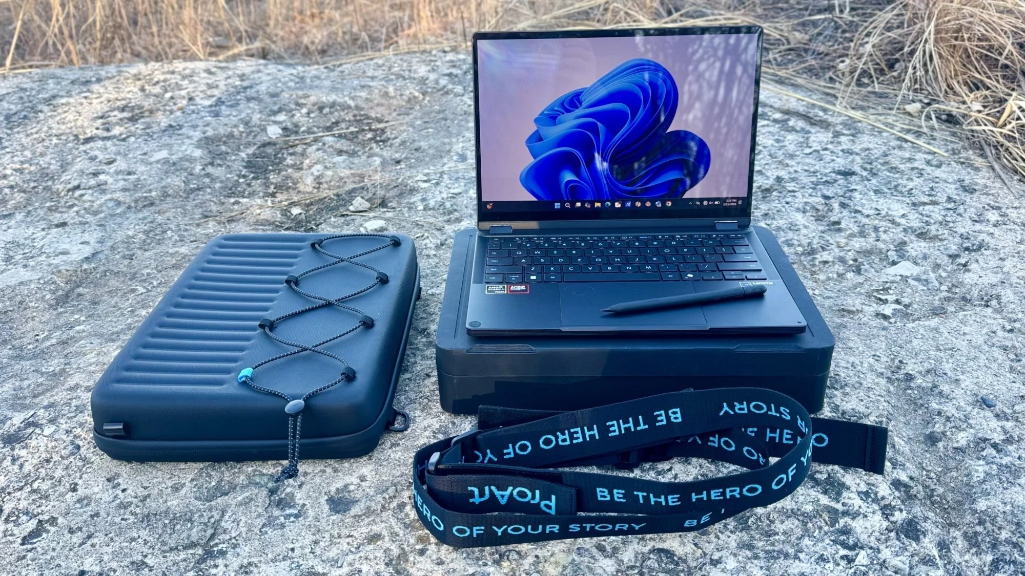 the asus proart gopro edition laptop with its accessories on a rock