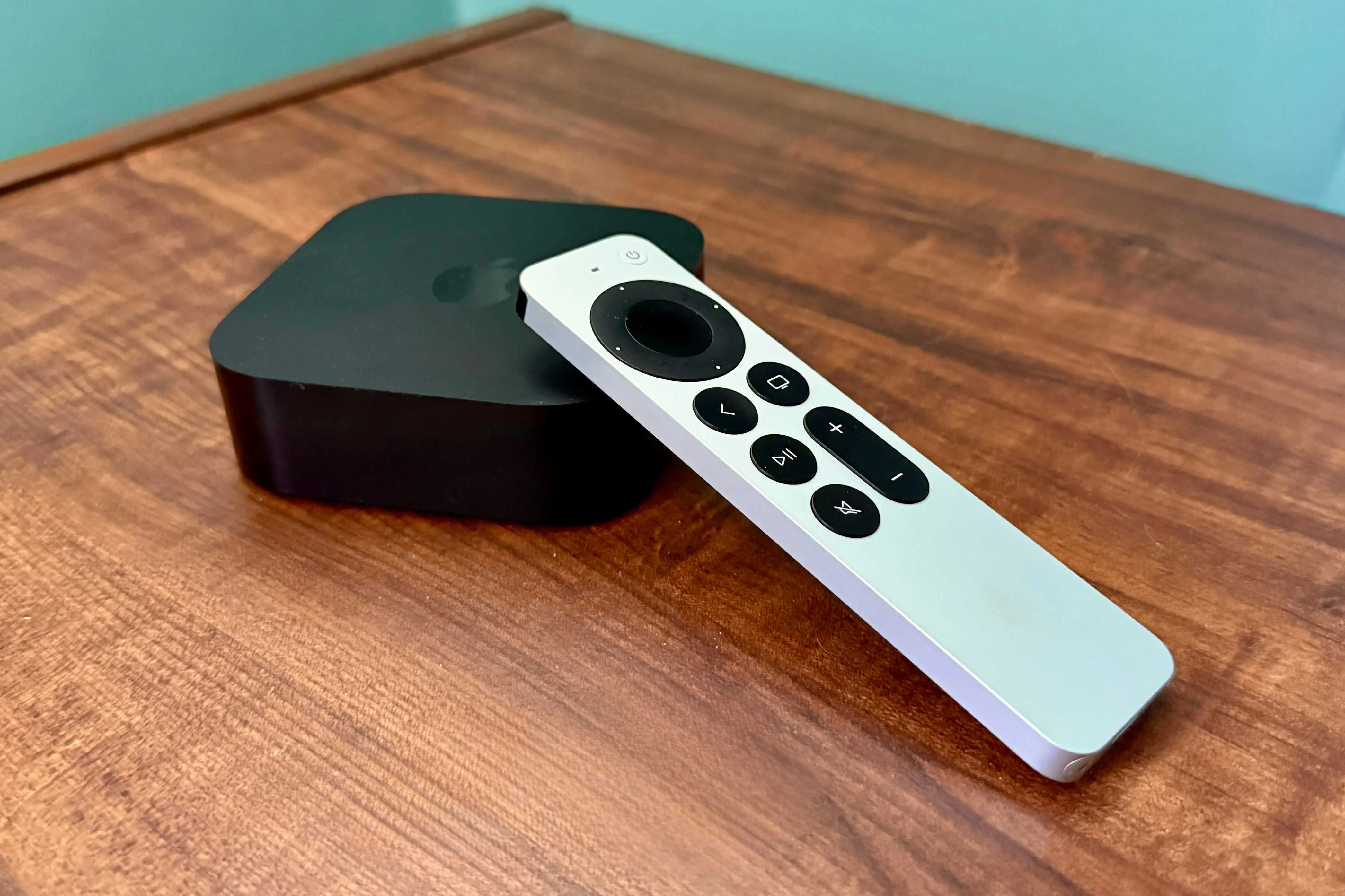 Apple TV 4K and the remote on a wooden table.