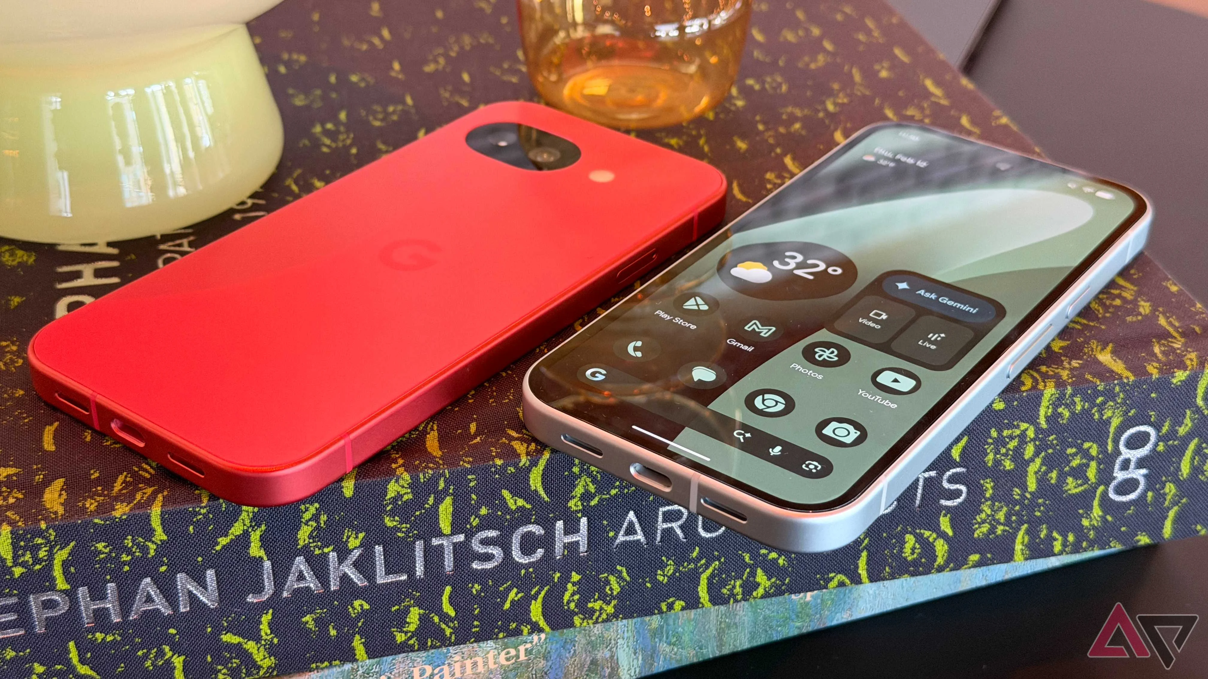 Two Google Pixel 10a phones sitting next to each other in Berry and Fog